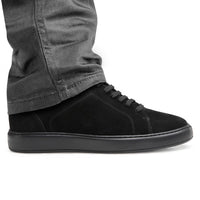 Mr. Jackie black sneakers worn with casual pants, highlighting height boost
