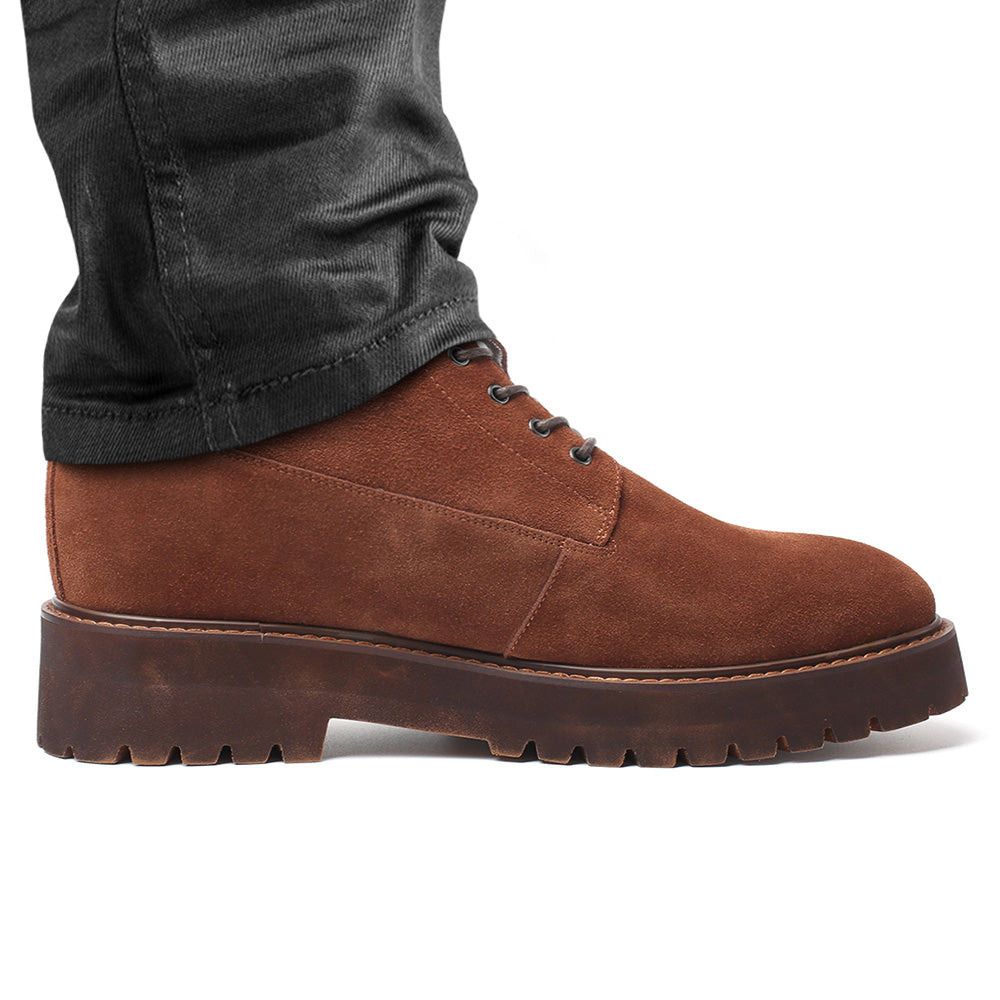 Mr. Moses brown elevator boots worn with pants, highlighting extreme height boost and stylish design.
