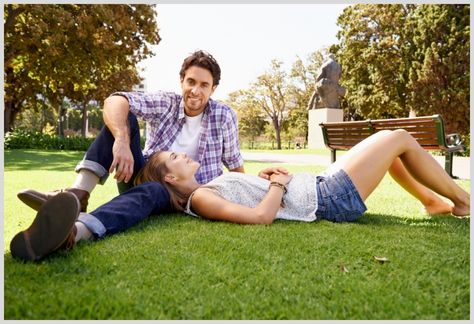 Couple lying in the grass wearing shoes